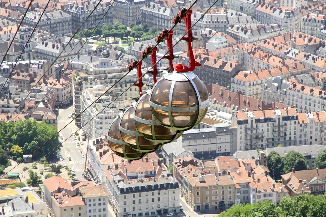 Quatre bulles du téléphérique de la Bastille au-dessus des toits de Grenoble